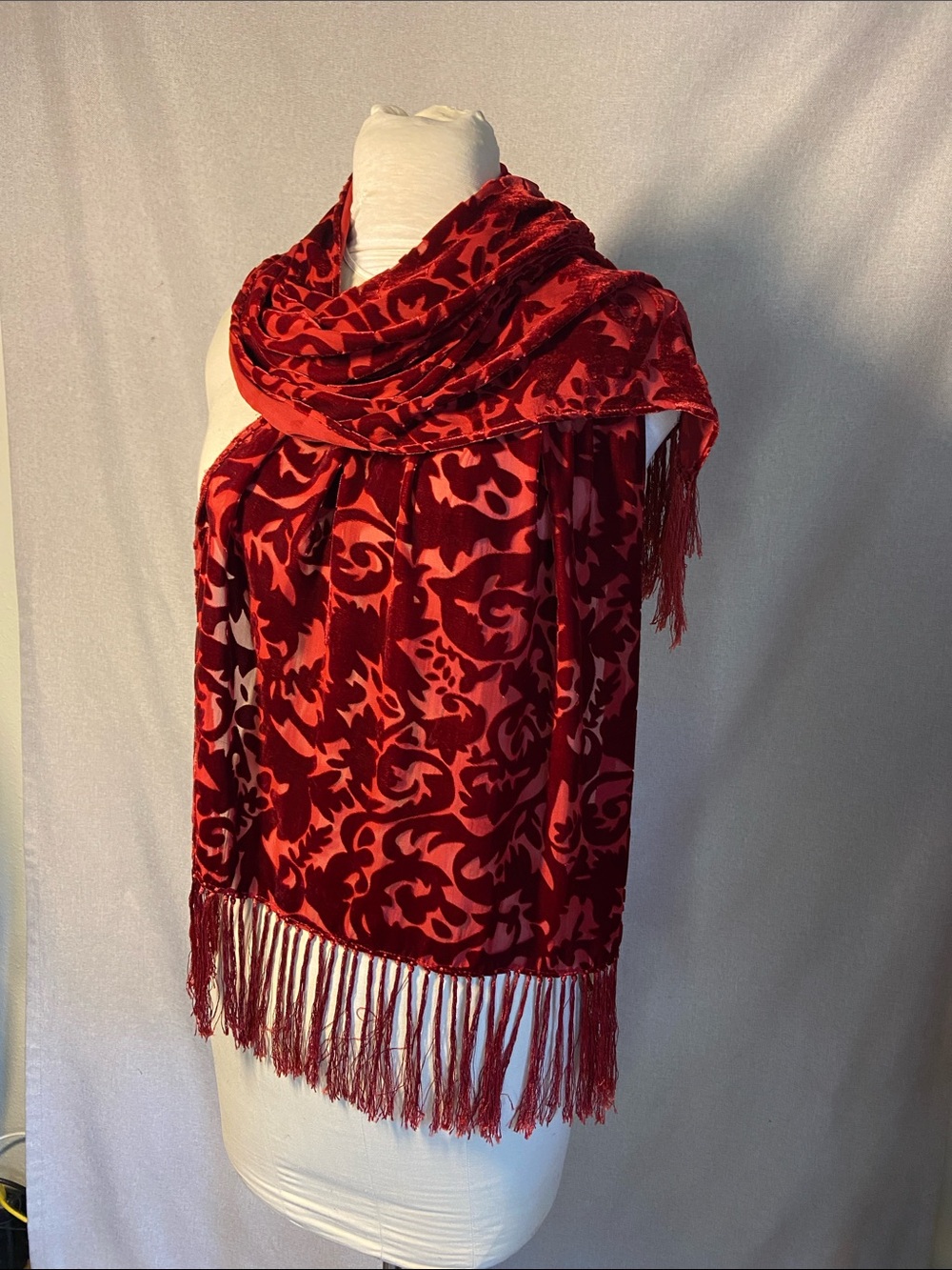 Red burnout velvet scarf featuring an intricate floral pattern.